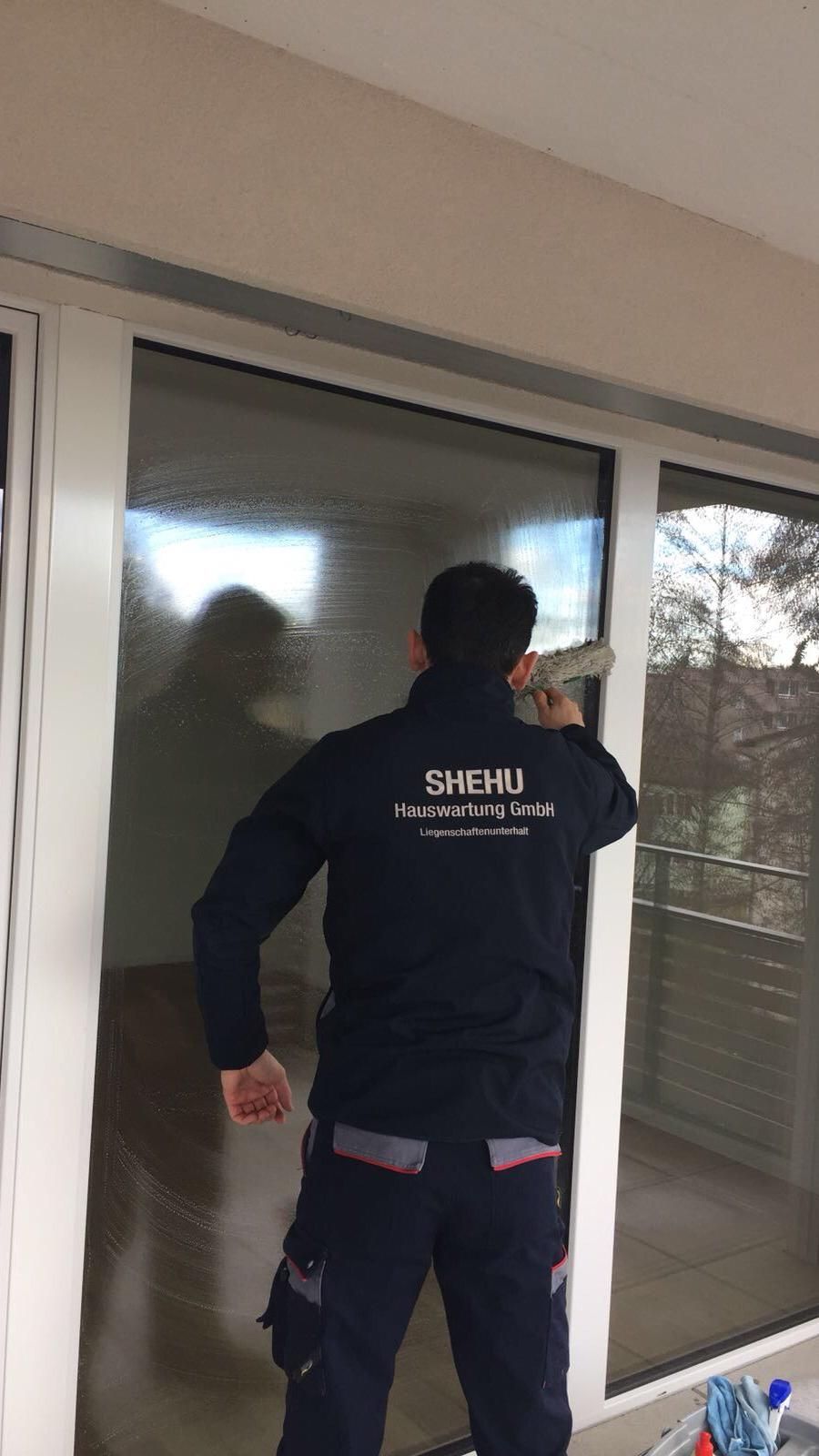 SHEHU Mitarbeiter beim Abziehen einer Fensterfront